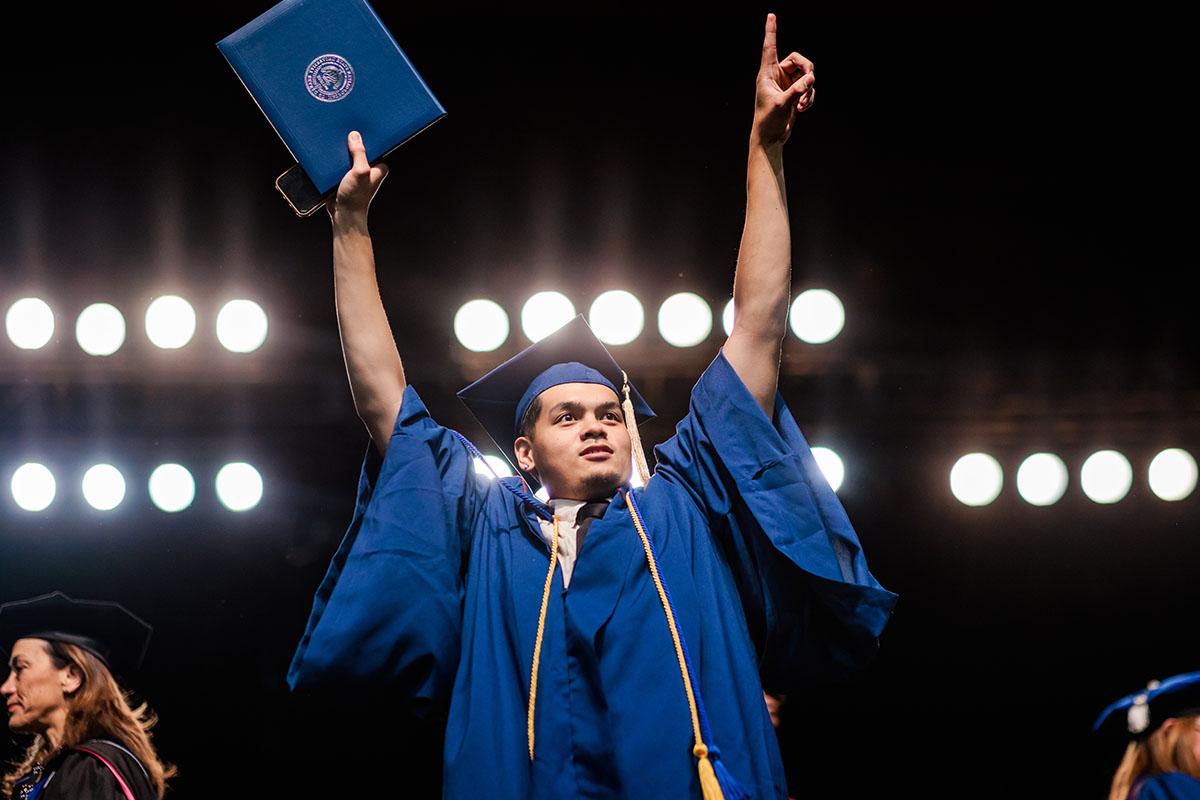 密歇根州立大学丹佛 graduate proudly receives his diploma.